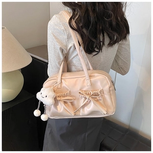 Detail of light beige bowling bag with side bow pockets and cute cloud plush charm pendant