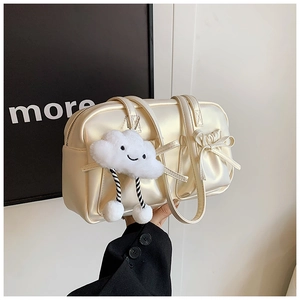 Detail of vintage cream bowling bag featuring pleated bow design and cute plush cloud charm