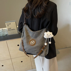 Detail view of grey vintage hobo bag with brown leather straps and cloud charm