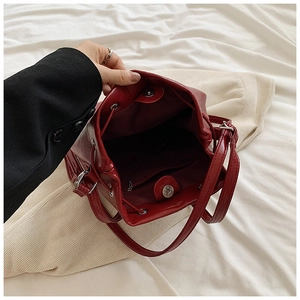 Dettaglio macro dell'interno della borsa a secchiello bordeaux con chiusura magnetica