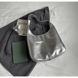 Detail of silver metallic hobo bag featuring crinkled texture and fashion brand label