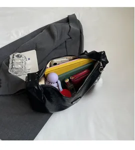 Intérieur spacieux du sac hobo noir plissé montrant la capacité pour téléphone et objets