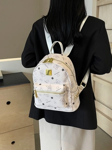 Mini weißer Rucksack mit schwarzen Bärenmustern und Goldreißverschlüssen am Modell