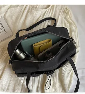 Top view of spacious black pleated shoulder bag interior showing daily items and silver zipper