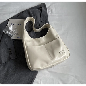 Detailed macro view of white crescent hobo bag with fashion logo and front pocket