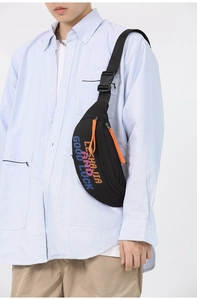Detail of vintage sports crossbody bag with colorful lettering and orange zipper puller