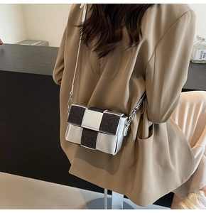 Macro shot of silver contrast patchwork bag with metallic squares and leather strap