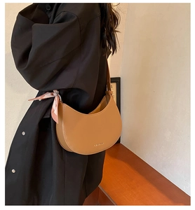 Gros plan d'un sac demi-lune en cuir PU marron orné d'un foulard en soie à motif floral