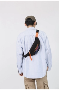 Detail view of black nylon chest bag with orange zipper and colorful typography design