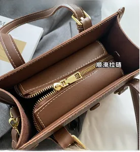 Innenansicht der dunkelbraunen Ledertasche mit goldenem Reißverschluss und Kontrastnaht
