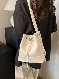Elegante borsa a secchiello beige in pelle verniciata lucida con farfalla argento