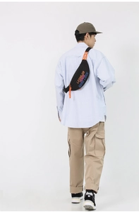Detail of black street style crossbody bag with orange strap and lucky letter printing