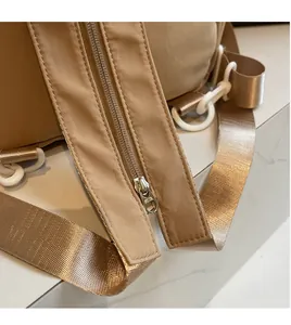 Detail shot of comfort shoulder straps and metal zipper on khaki nylon backpack