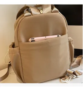 Detail of durable front pocket and side drawstring storage on khaki nylon backpack