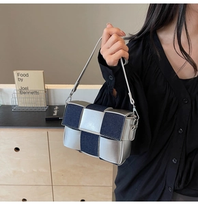 Detail of silver metallic leather and blue denim patchwork on a woven crossbody bag