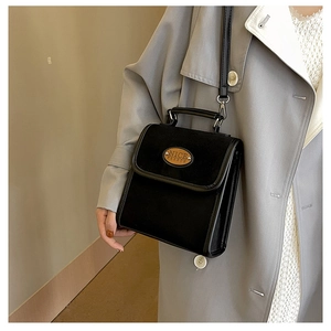 Detail of vintage black suede crossbody bag with NICE FASHION plaque and smooth trim