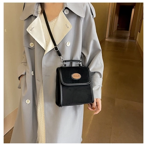 Close-up of black retro shoulder bag with NICE FASHION leather patch and silver hardware