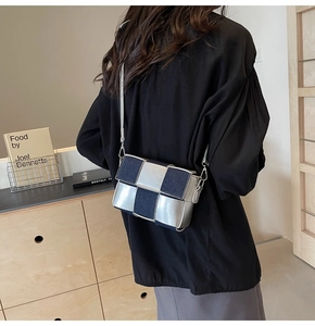 Detail of crossbody bag featuring silver and denim blue woven checkerboard pattern