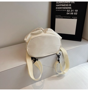 Detail des cremefarbenen Faltenrucksacks mit Kordelzug und schwarzen Metallschnallen