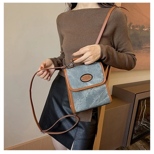 Detail of vintage grey canvas and brown leather crossbody bag with nice fashion logo