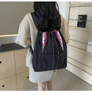 Detalle de una mochila negra con cordón y cinta SUCHAO con correas anchas para el hombro