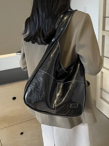 Large black glossy leather tote bag with white contrast stitching for daily commute