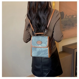 Detail of vintage canvas backpack with brown leather trim and NICE FASHION leather patch