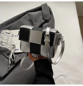 Close-up of contrast silver and black square bag with adjustable shoulder strap