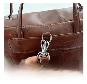 Detailed macro view of high-quality silver metal hooks on a brown leather backpack