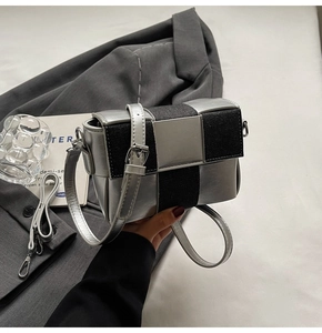 Detail of color-block mini square bag with silver metallic and black denim textures
