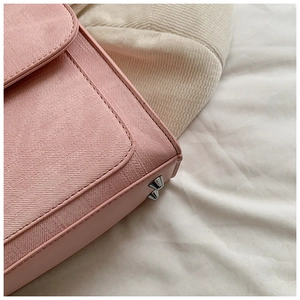 Gros plan du sac à bandoulière rose avec rivets métalliques argentés et coutures soignées