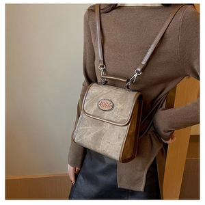 Detailed view of vintage khaki suede backpack on model with thin shoulder straps