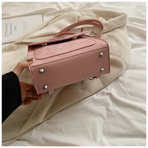 Détail du sac à bandoulière rose montrant les rivets de protection en métal argenté