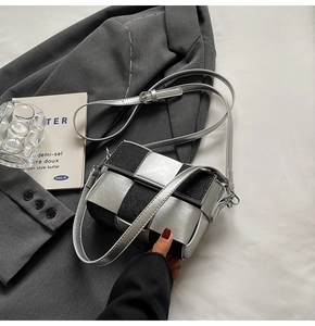 Detail of silver weave and black denim crossbody bag on professional minimalist background