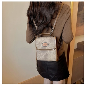 Back view of model wearing vintage marble-textured backpack with brown PU leather trim