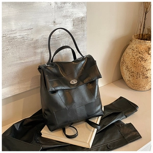 Detail of minimalist black leather backpack with square patchwork and silver twist lock
