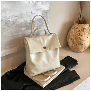 Detail of cream leather backpack with geometric stitching and silver metal turn-lock