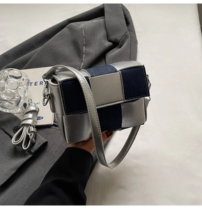 Detail of silver metallic and navy denim woven square shoulder bag on a suit