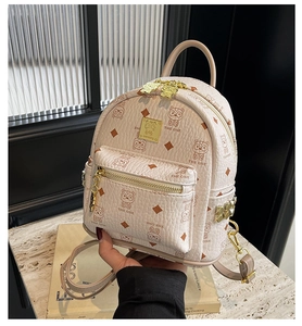 Detailed macro view of cream PU leather backpack with bear print and gold-tone zippers