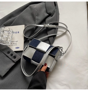 Detail of silver-blue checkerboard pattern and metallic buckle on small crossbody bag