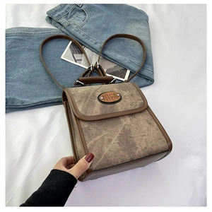 Detail of vintage brown suede backpack with faux leather trim and NICE FASHION badge