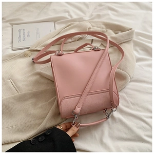 Détail du patchwork en cuir rose et tissu rayé sur un petit sac à main élégant