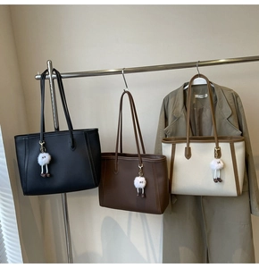 Dettaglio di borse tote in tre colori con ciondoli in peluche e trama a grana fine