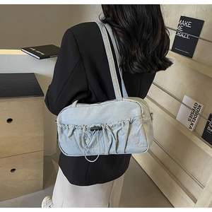 Detail of light blue ruched shoulder bag with adjustable drawstring and nylon texture