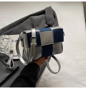 Detail of silver metallic and blue denim patchwork woven crossbody bag with two straps