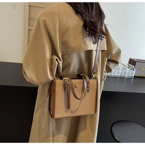 Rückansicht eines Modells mit einer Khaki-Braunen Leder-Umhängetasche im Vintage-Stil