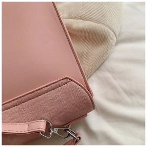 Détail de patchwork en cuir rose et tissu sergé avec boucle en métal argenté du sac