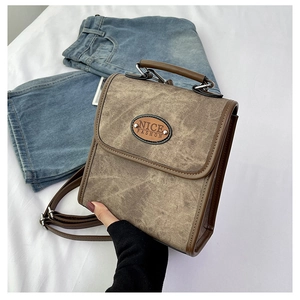 Detail view of vintage brown faux suede handbag with Nice Fashion logo and top handle