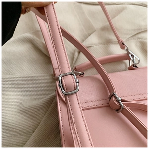Détails d'un sac à main en cuir rose avec boucles argentées et coutures précises