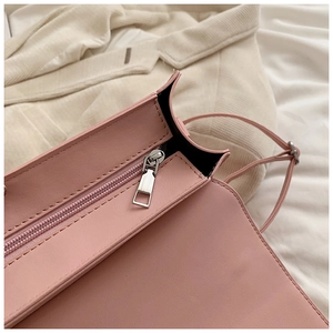 Détail du sac à main en cuir rose avec fermeture éclair argentée et coutures précises